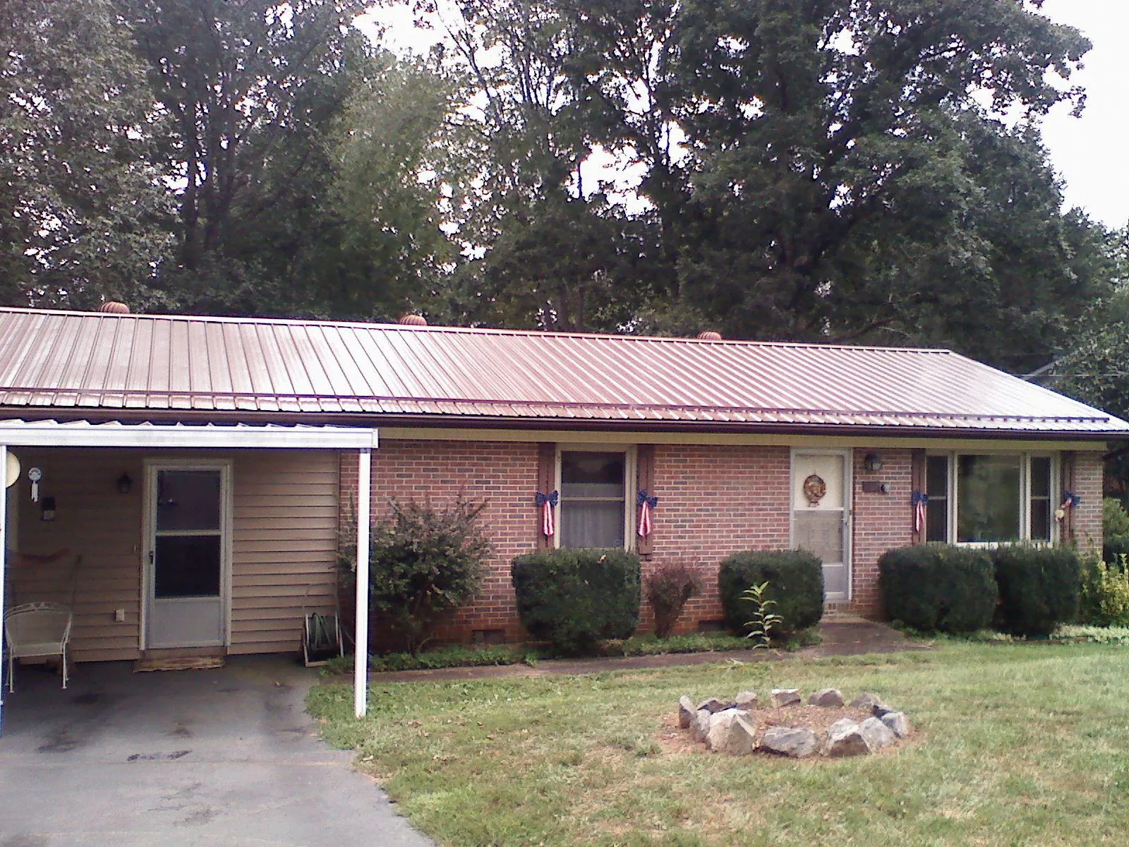 Bronze metal roof and carport on a brick ranch home — Roof Repair work by our crew in Tower City
