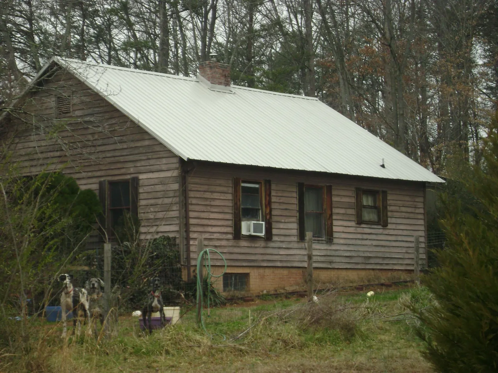 White metal roof on an old wood sided farmhouse, from a Metal Roof Installation job in Tower City